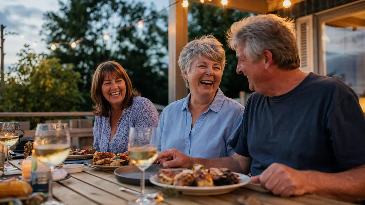 Gwen, Bev, and Ray gathered around a long outdoor table at a Sunday cookout
